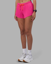 Woman wearing Accelerate 3" Pleated Running Short - Ultra Pink | Model:Rhiley | Size:S