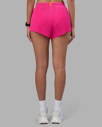 Woman wearing Accelerate 3" Pleated Running Short - Ultra Pink | Model:Rhiley | Size:S