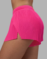 Woman wearing Accelerate 3" Pleated Running Short - Ultra Pink | Model:Rhiley | Size:S