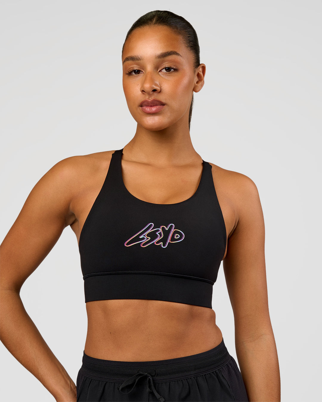 Woman wearing Accelerate Graphic Sports Bra - Black-Radiate | Model:Rosie | Size:S