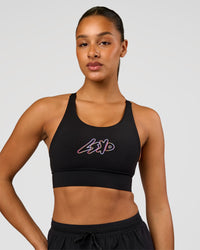 Woman wearing Accelerate Graphic Sports Bra - Black-Radiate | Model:Rosie | Size:S