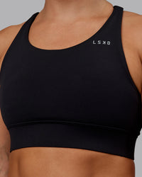 Woman wearing Accelerate Sports Bra - Black | Set:true | Angle:closeup | Model:Lyss | Size:S