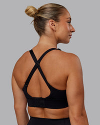 Woman wearing Accelerate Sports Bra - Black | Set:true | Angle:back | Model:Lyss | Size:S