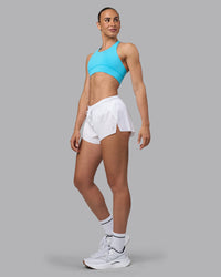 Woman wearing Accelerate Sports Bra - Blue Atoll | Model:Sophie | Size:S