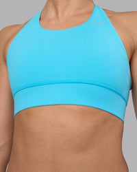 Woman wearing Accelerate Sports Bra - Blue Atoll | Set:true | Angle:closeup | Model:Sophie | Size:S