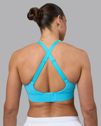Woman wearing Accelerate Sports Bra - Blue Atoll | Set:true | Angle:back | Model:Sophie | Size:S