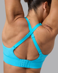 Woman wearing Accelerate Sports Bra - Blue Atoll | Model:Sophie | Size:S