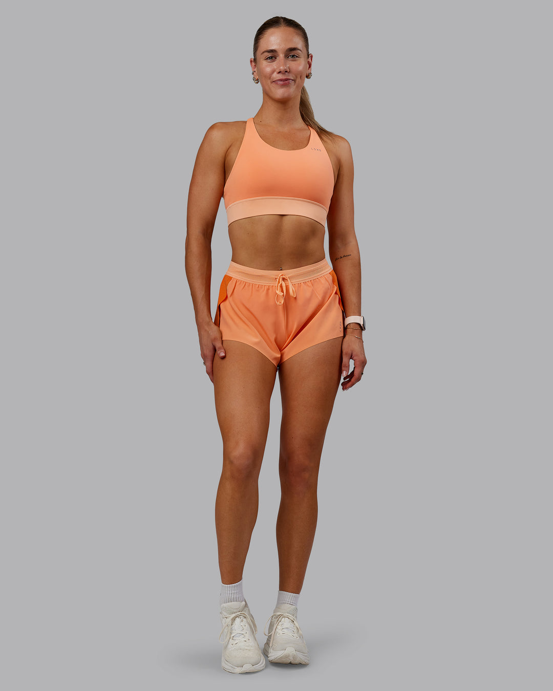 Woman wearing Accelerate Sports Bra - Cantaloupe Colourblock