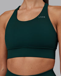 Woman wearing Accelerate Sports Bra - Dark Moss | Set:true | Angle:closeup | Model:Rhiley | Size:S