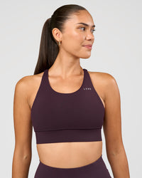 Woman wearing Accelerate Sports Bra - Midnight Plum | Set:true | Angle:front | Model:Rhiley | Size:S