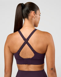 Woman wearing Accelerate Sports Bra - Midnight Plum | Set:true | Angle:back | Model:Rhiley | Size:S