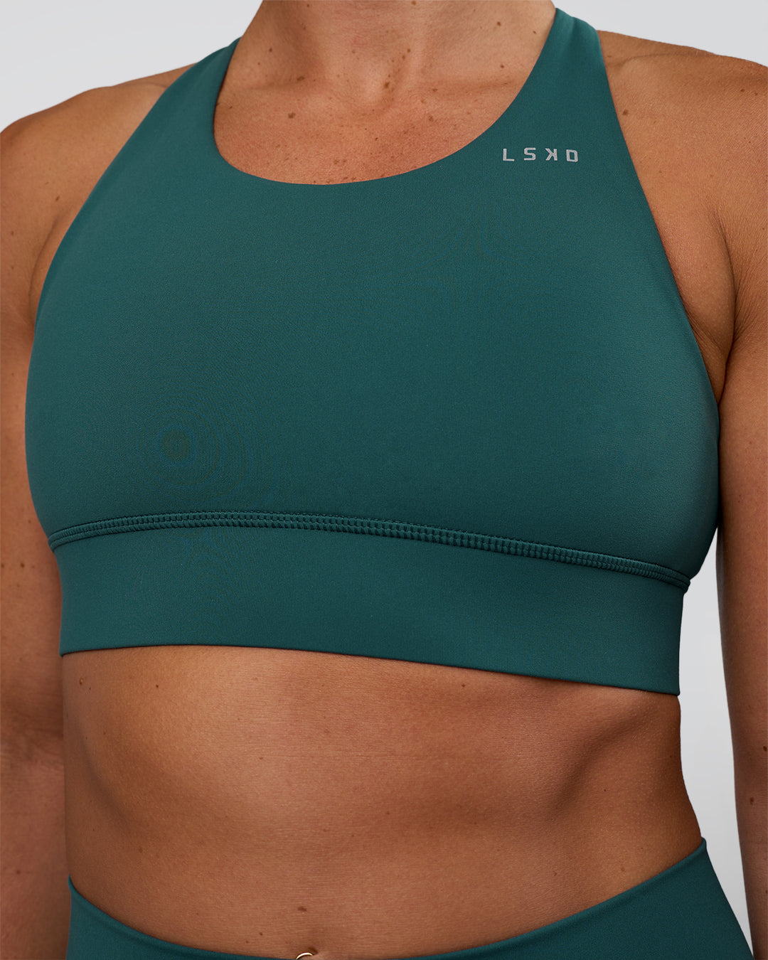 Woman wearing Accelerate Sports Bra - Transformative Teal | Set:true | Angle:closeup | Model:Sav | Size:S