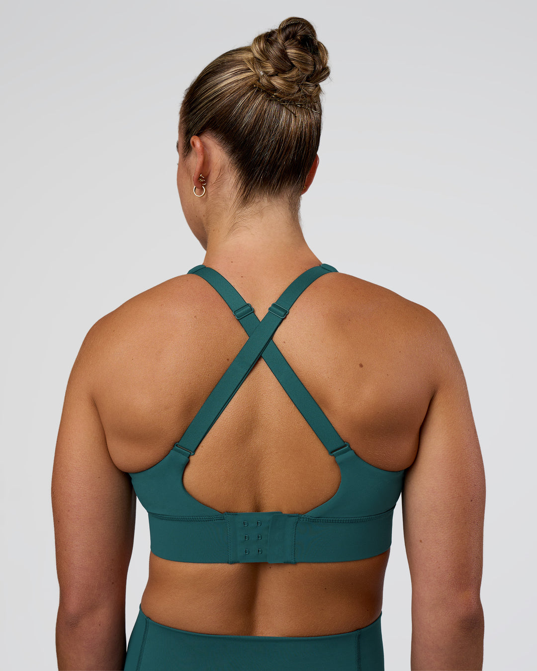 Woman wearing Accelerate Sports Bra - Transformative Teal | Set:true | Angle:back | Model:Sav | Size:S