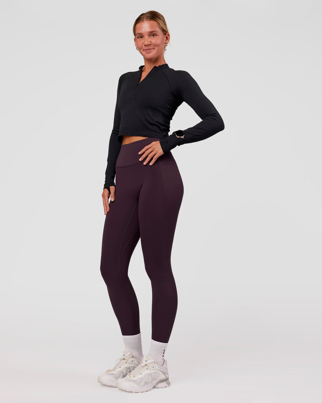 Woman wearing AeroFLX+ Long Sleeve Skimmer Half Zip - Black Marl | Model:Amity | Size:S