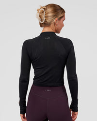 Woman wearing AeroFLX+ Long Sleeve Skimmer Half Zip - Black Marl | Model:Amity | Size:S