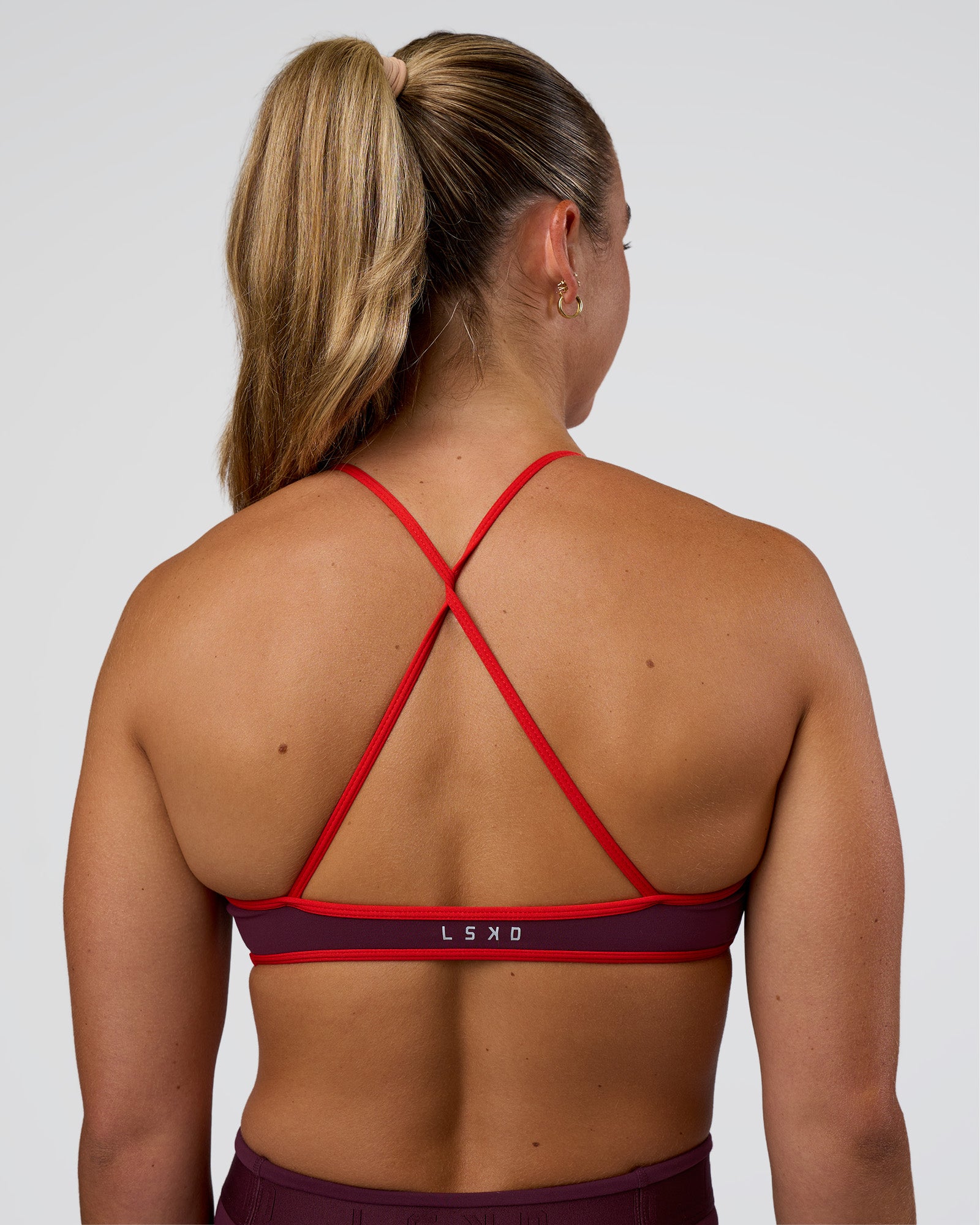 Woman wearing Ambience Sports Bra - Cherry Lacquer-Flame | Model:Sav | Size:S