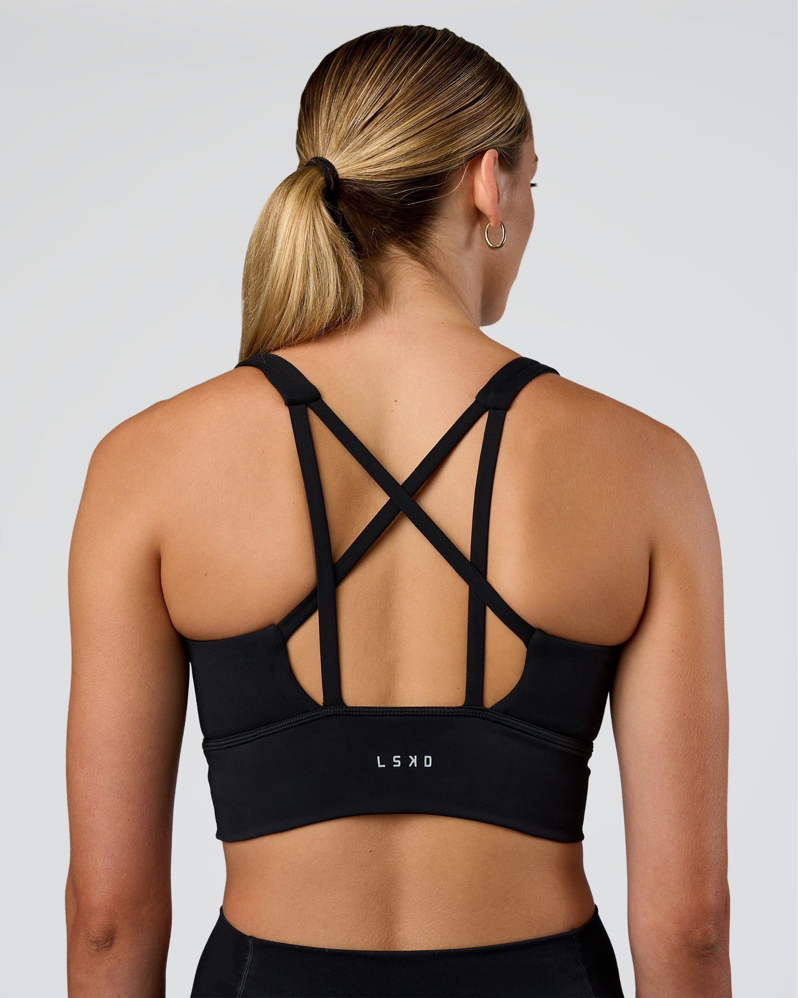 Woman wearing Circuit Longline Sports Bra - Black | Model:Evie | Size:S