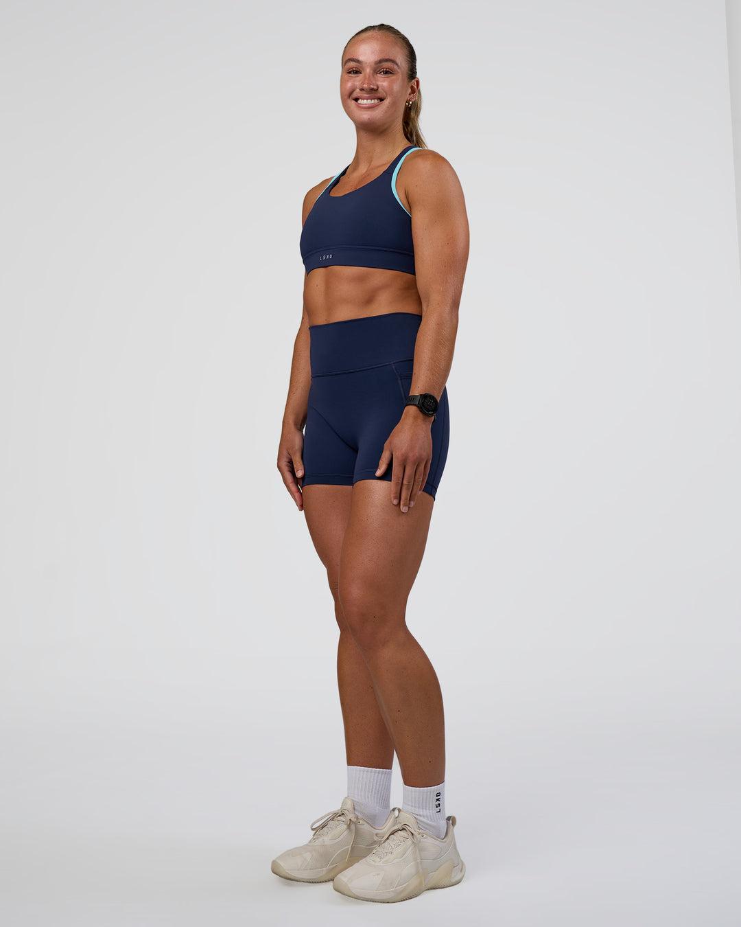 Woman wearing Distinction Sports Bra 2.0 - Future Navy-Baltic Sea | Model:Sav | Size:S