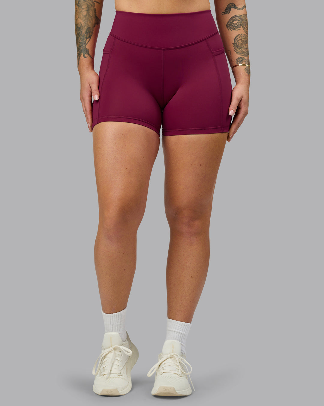 Woman wearing Elite High-Rise 4&quot; Short Pockets - Plum Berry | Model:Robyn | Size:S