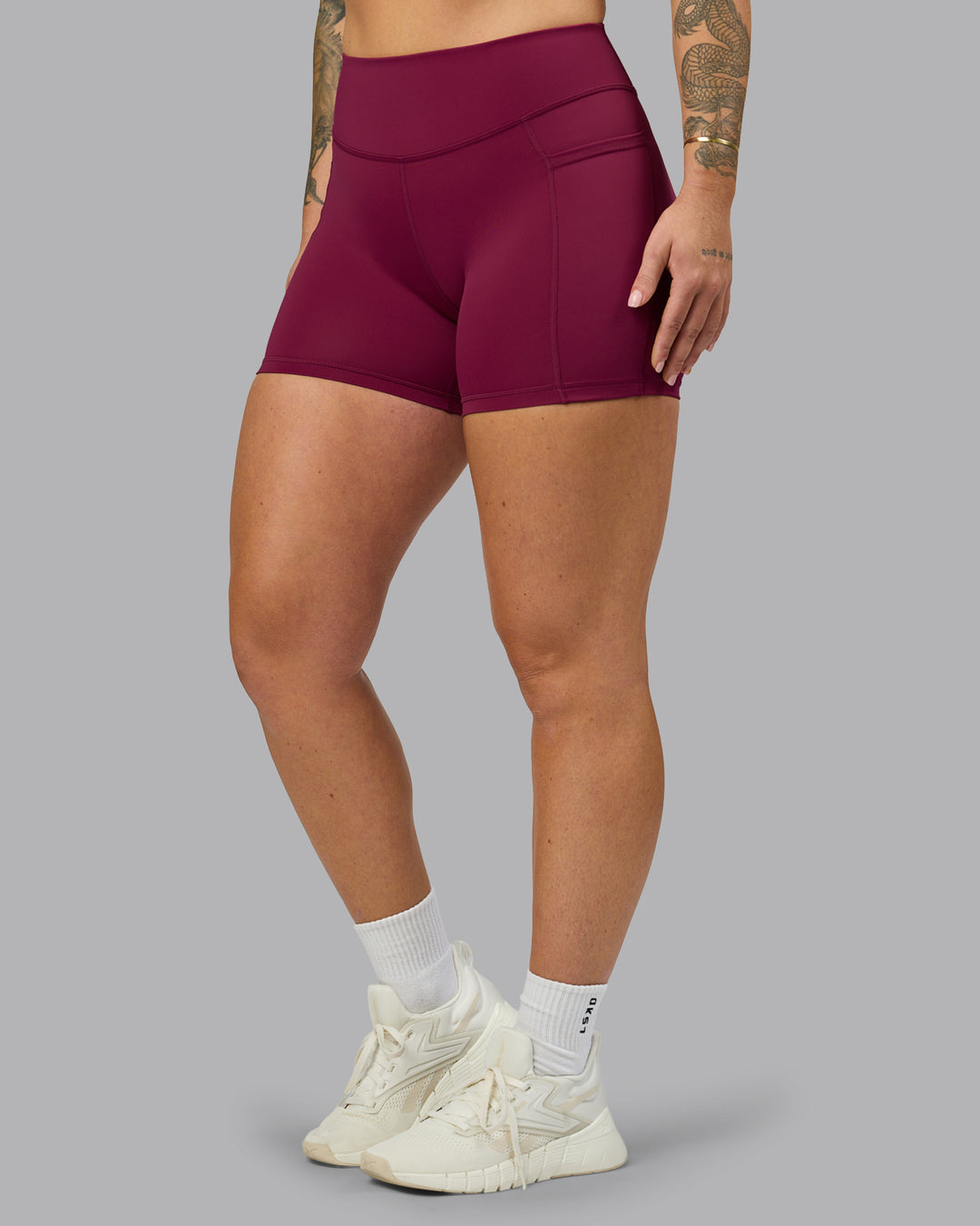 Woman wearing Elite High-Rise 4&quot; Short Pockets - Plum Berry | Model:Robyn | Size:S