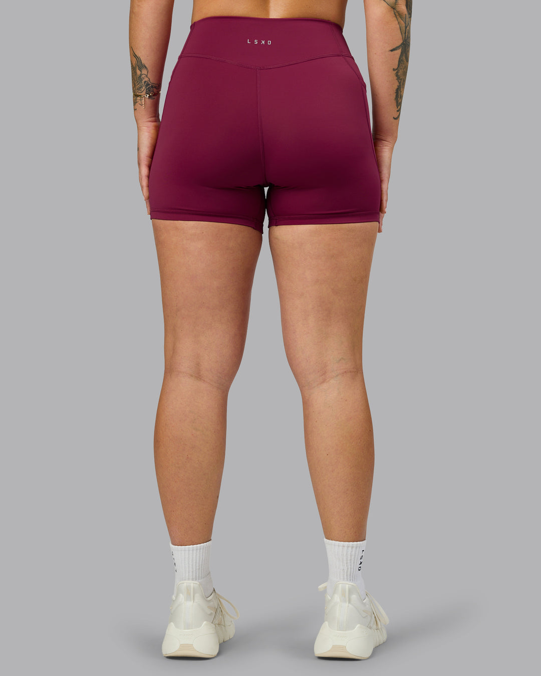 Woman wearing Elite High-Rise 4&quot; Short Pockets - Plum Berry | Model:Robyn | Size:S