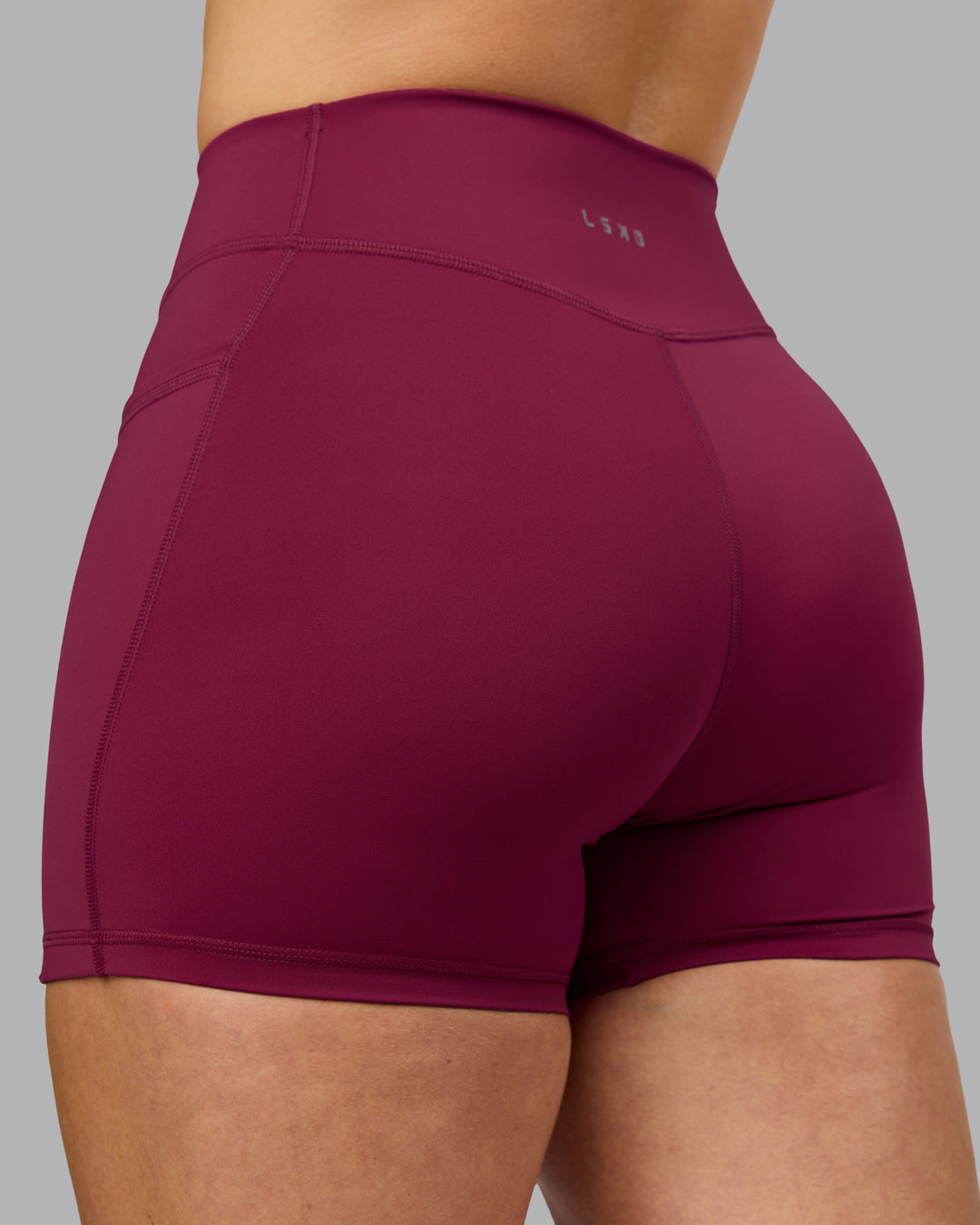 Woman wearing Elite High-Rise 4&quot; Short Pockets - Plum Berry | Model:Robyn | Size:S