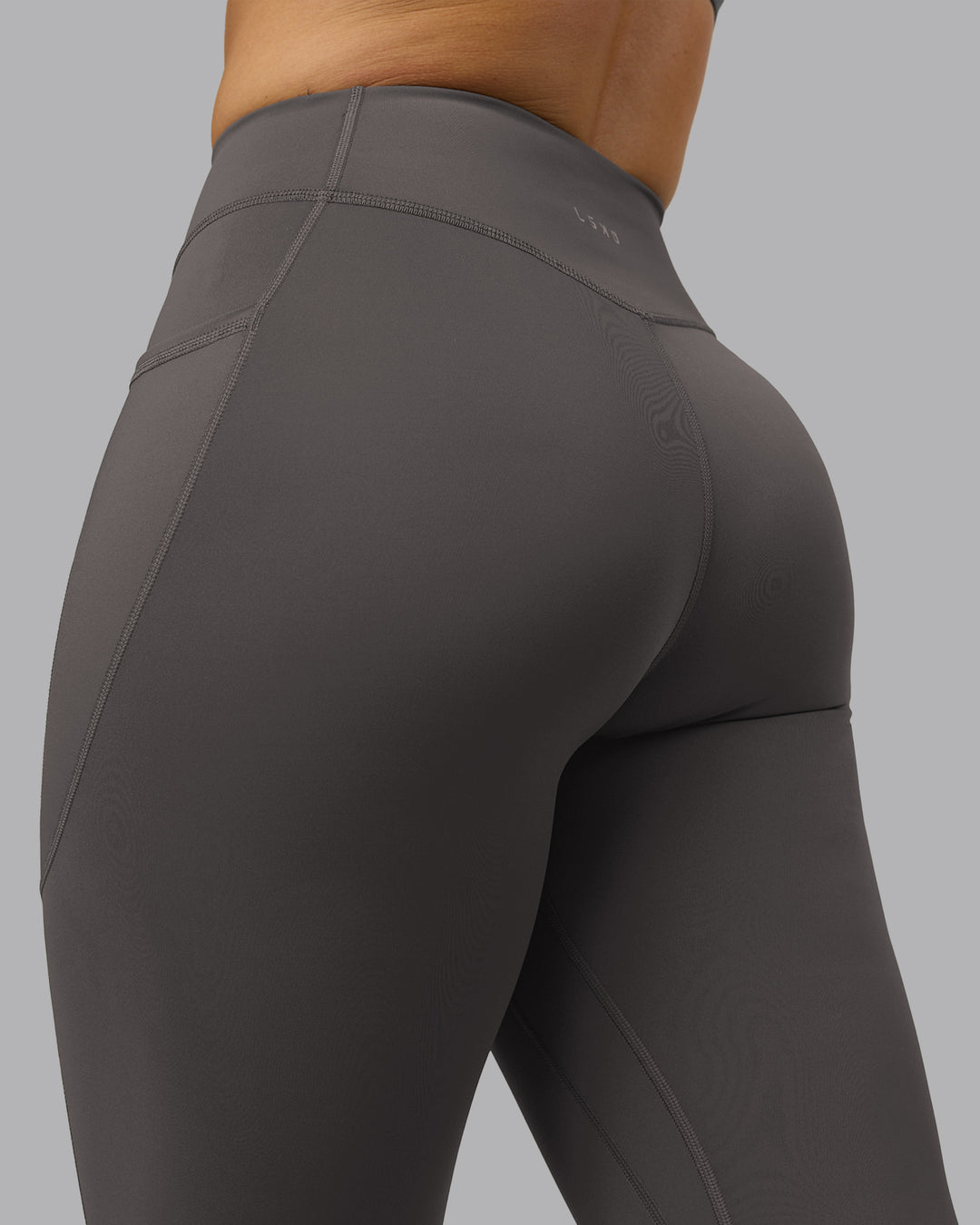 Woman wearing Elite High-Rise 7/8 Legging Pockets - Dark Storm | Model:Robyn | Size:S
