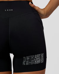 Woman wearing Elite Hype Reflective Run High-Rise 5" Short Pockets - Black-Hype Reflective | Model:Amity | Size:S