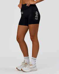 Woman wearing Elite Hype Reflective Run High-Rise 5" Short Pockets - Black-Hype Reflective | Model:Amity | Size:S