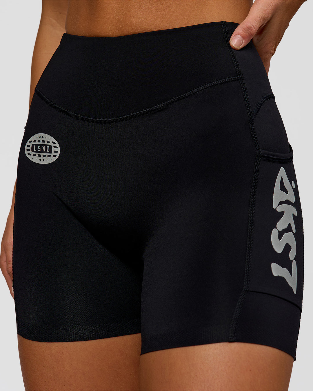 Woman wearing Elite Hype Reflective Run High-Rise 5" Short Pockets - Black-Hype Reflective | Model:Amity | Size:S