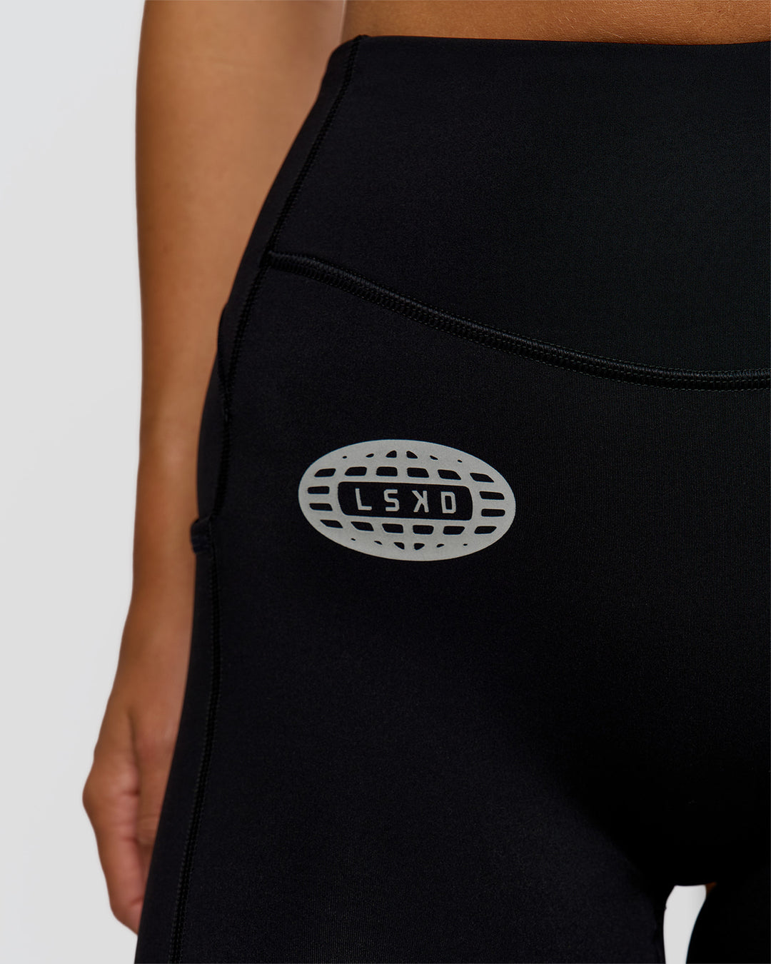 Woman wearing Elite Hype Reflective Run High-Rise 5" Short Pockets - Black-Hype Reflective | Model:Amity | Size:S