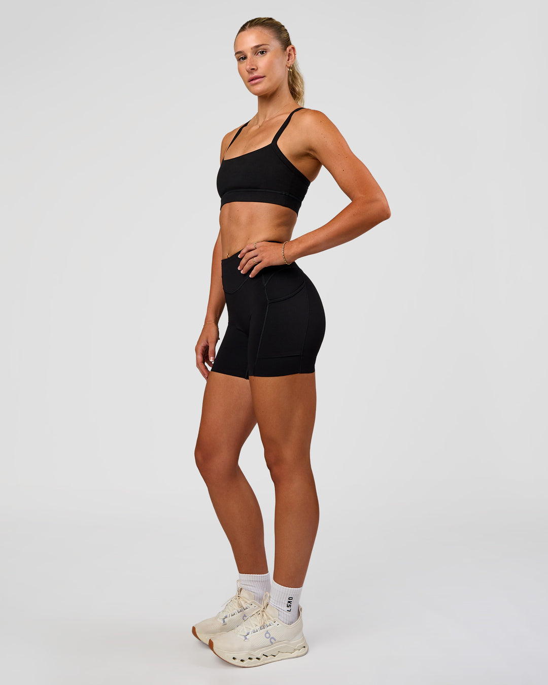 Woman wearing Elite Run High-Rise 5" Short Pockets - Black | Model:Emelia | Size:S