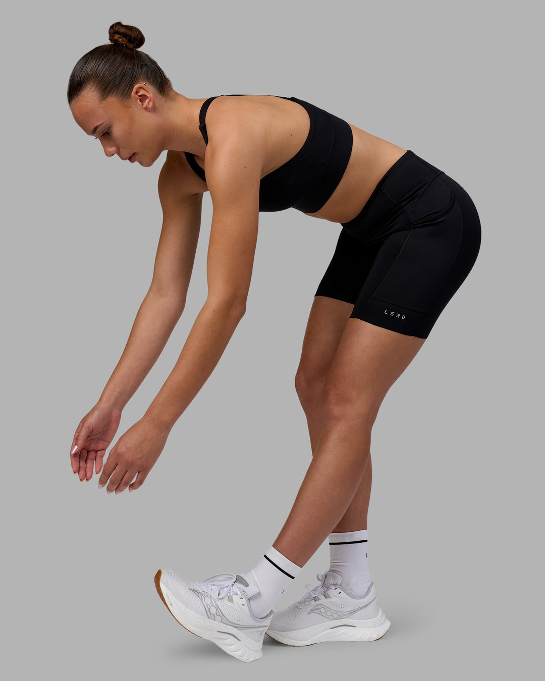 Woman wearing Elite Run High-Rise 7&quot; Short Pockets - Black | Model:Charlize | Size:S