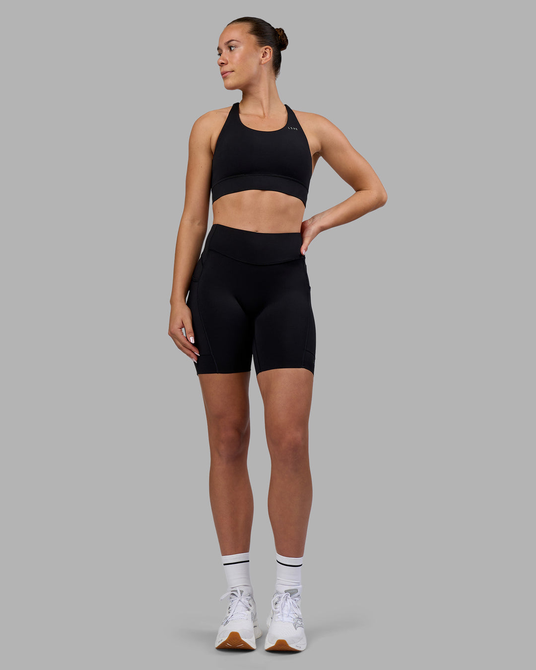 Woman wearing Elite Run High-Rise 7&quot; Short Pockets - Black | Model:Charlize | Size:S