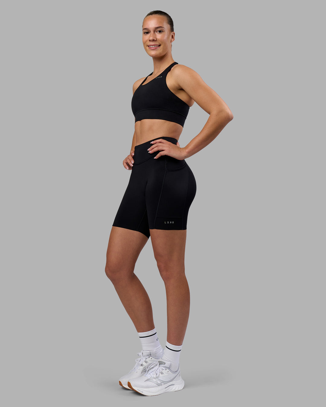 Woman wearing Elite Run High-Rise 7&quot; Short Pockets - Black | Model:Charlize | Size:S