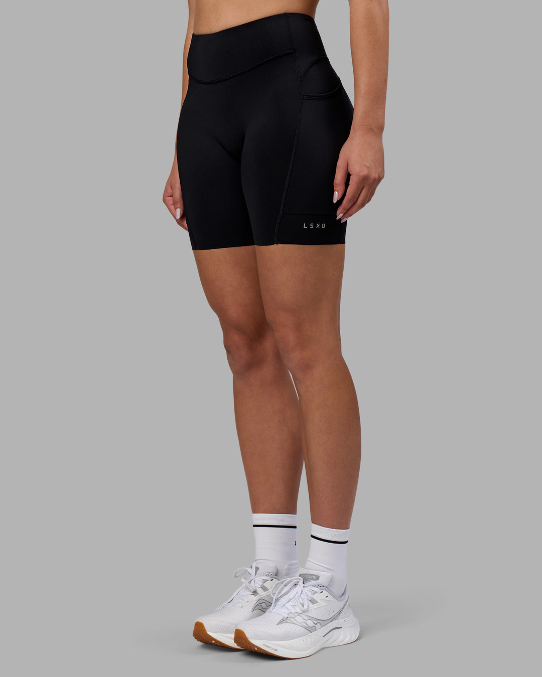 Woman wearing Elite Run High-Rise 7&quot; Short Pockets - Black | Model:Charlize | Size:S