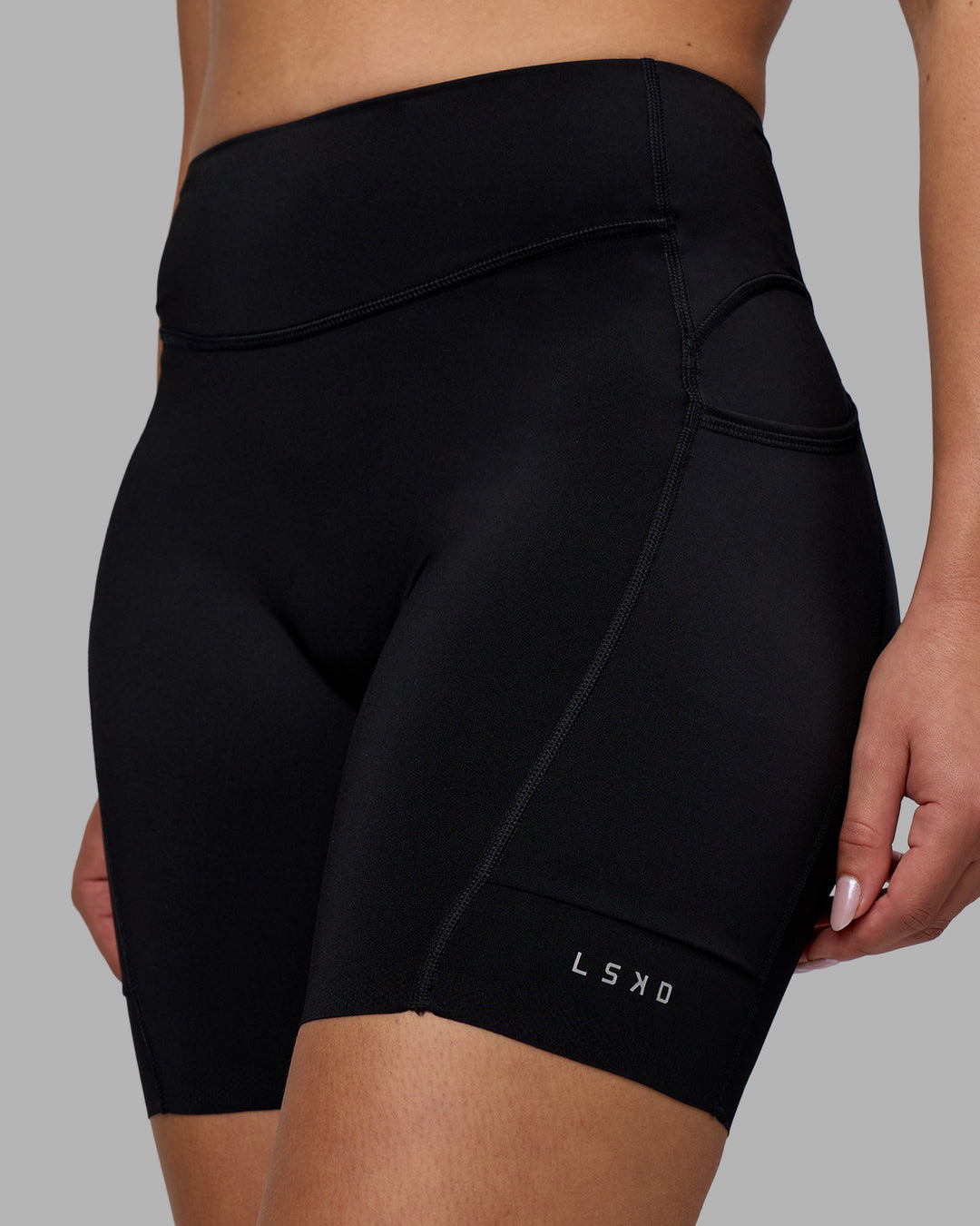 Woman wearing Elite Run High-Rise 7&quot; Short Pockets - Black | Model:Charlize | Size:S