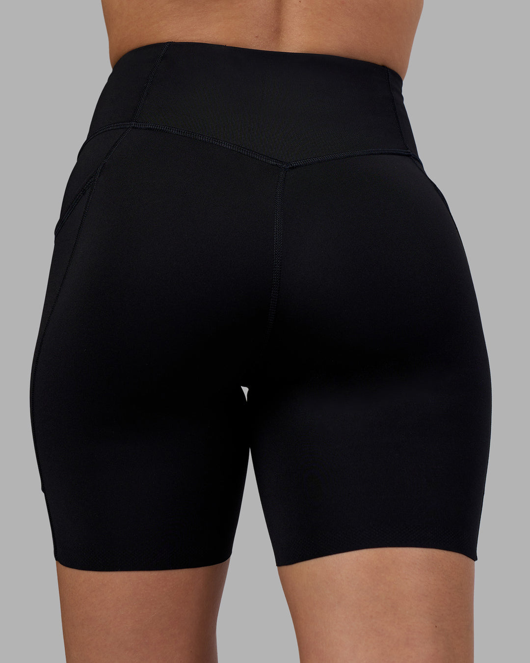 Woman wearing Elite Run High-Rise 7&quot; Short Pockets - Black | Model:Charlize | Size:S