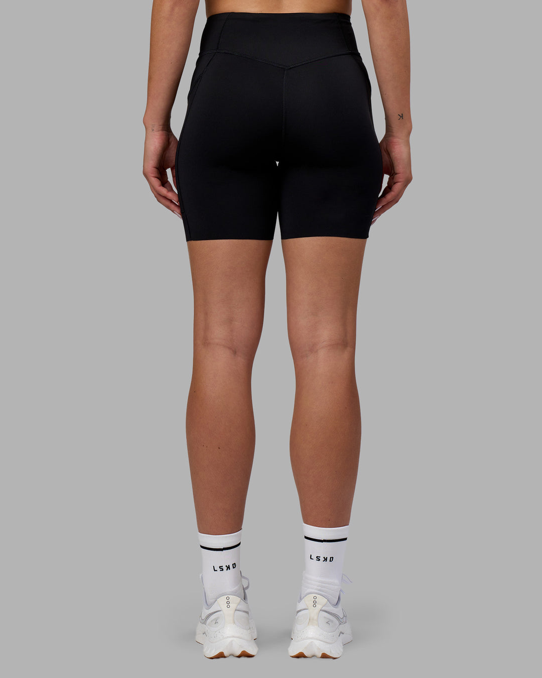Woman wearing Elite Run High-Rise 7&quot; Short Pockets - Black | Model:Charlize | Size:S