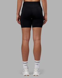 Woman wearing Elite Run High-Rise 7" Short Pockets - Black | Model:Charlize | Size:S