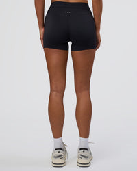 Woman wearing Elixir Defined High-Rise 4" Short Pockets - Black | Model:Bianca | Size:S