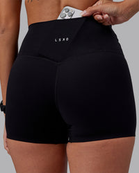 Woman wearing Elixir High-Rise 4" Short - Black | Model:Rhiley | Size:S