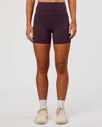 Woman wearing Elixir Ultra High-Rise 4" Short Pockets - Midnight Plum | Model:Emelia | Size:S