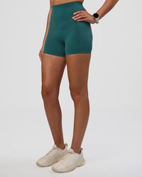 Woman wearing Elixir Ultra High-Rise 4" Short Pockets - Transformative Teal | Model:Myrte | Size:S