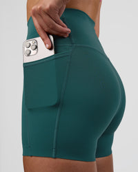 Woman wearing Elixir Ultra High-Rise 4" Short Pockets - Transformative Teal | Model:Myrte | Size:S