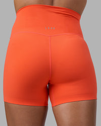 Woman wearing Elixir Ultra High-Rise 4" Short - Ultra Orange | Model:Katie | Size:S
