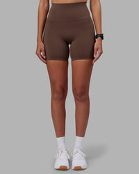 Woman wearing Elixir Ultra High-Rise 6" Short Pockets - Chocolate Martini | Model:Rhiley | Size:S