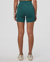 Woman wearing Elixir Ultra High-Rise 6" Short Pockets - Transformative Teal | Model:Myrte | Size:S