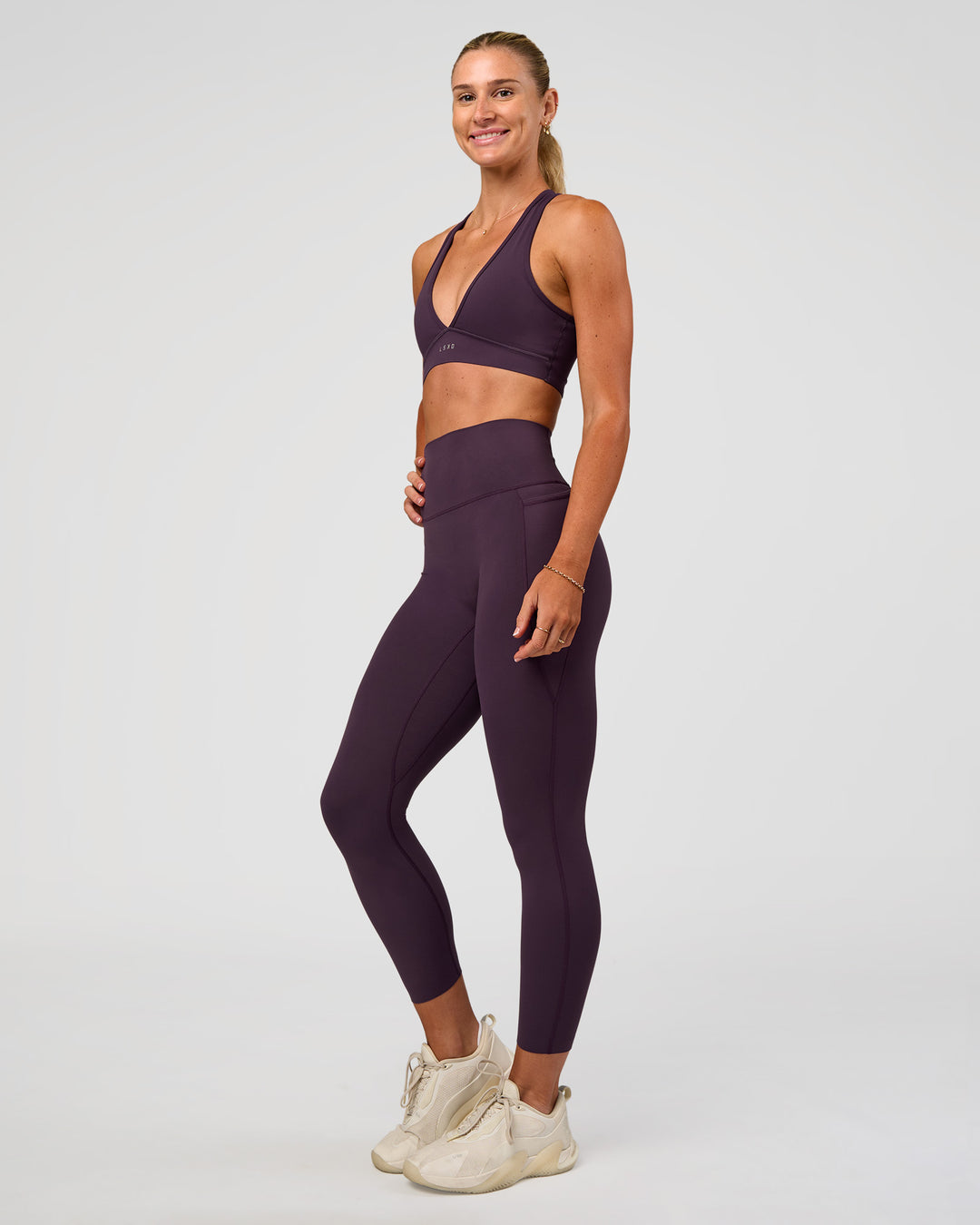 Woman wearing Elixir Ultra High-Rise 7/8 Legging Pockets - Midnight Plum | Model:Emelia | Size:S