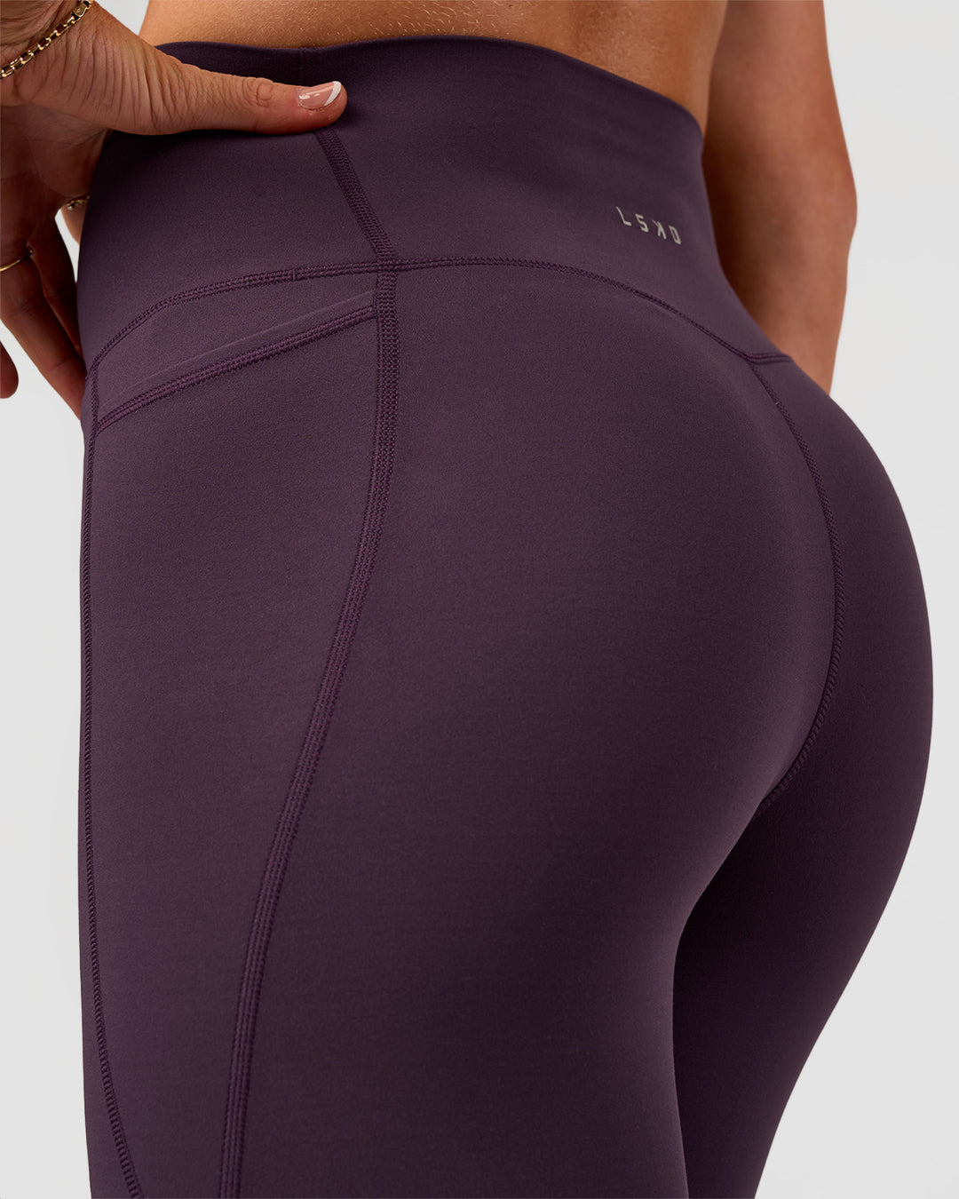 Woman wearing Elixir Ultra High-Rise 7/8 Legging Pockets - Midnight Plum | Model:Emelia | Size:S